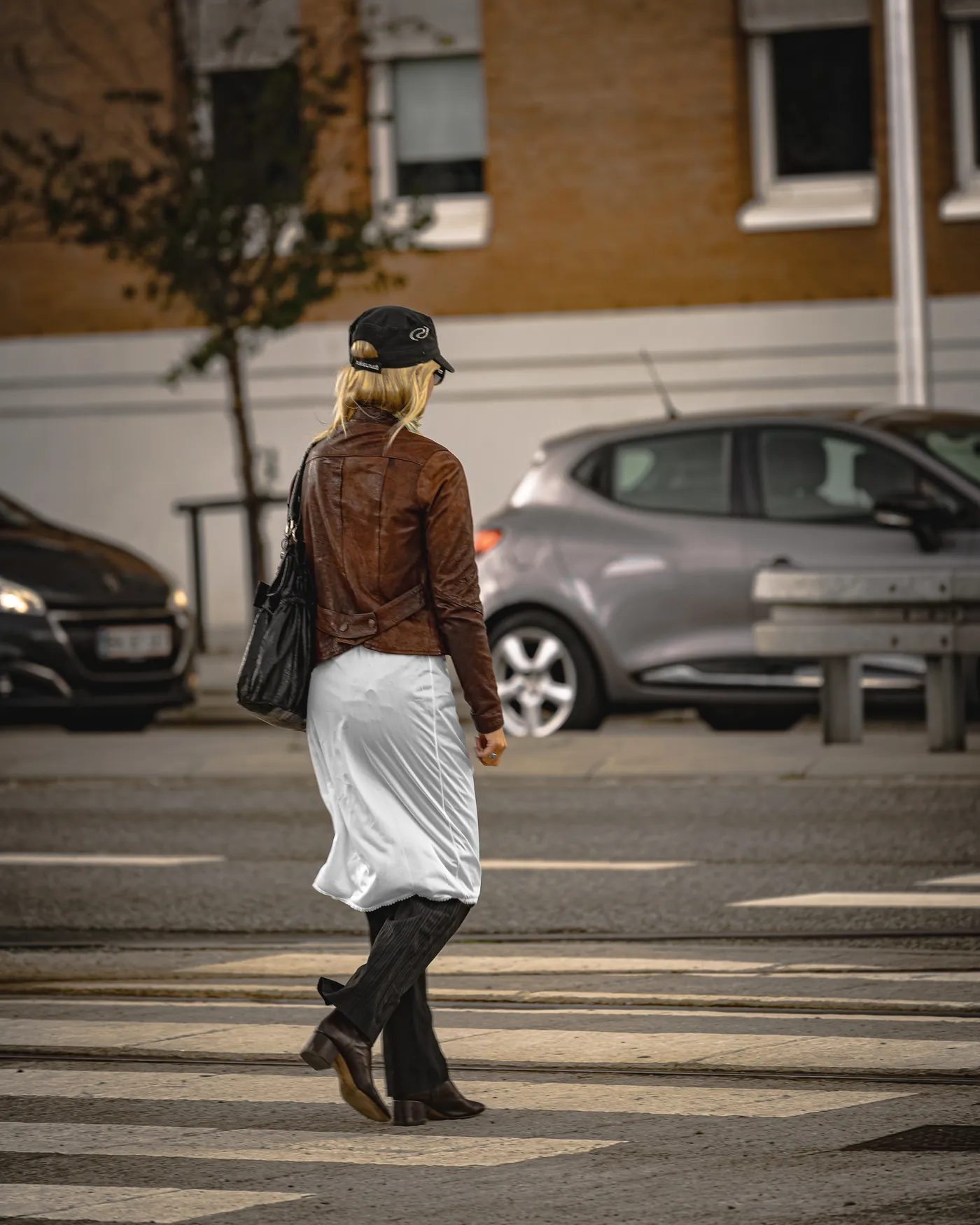Fotografi af Mads Dyg: Kvinde i hvid nederdel krydser vejen