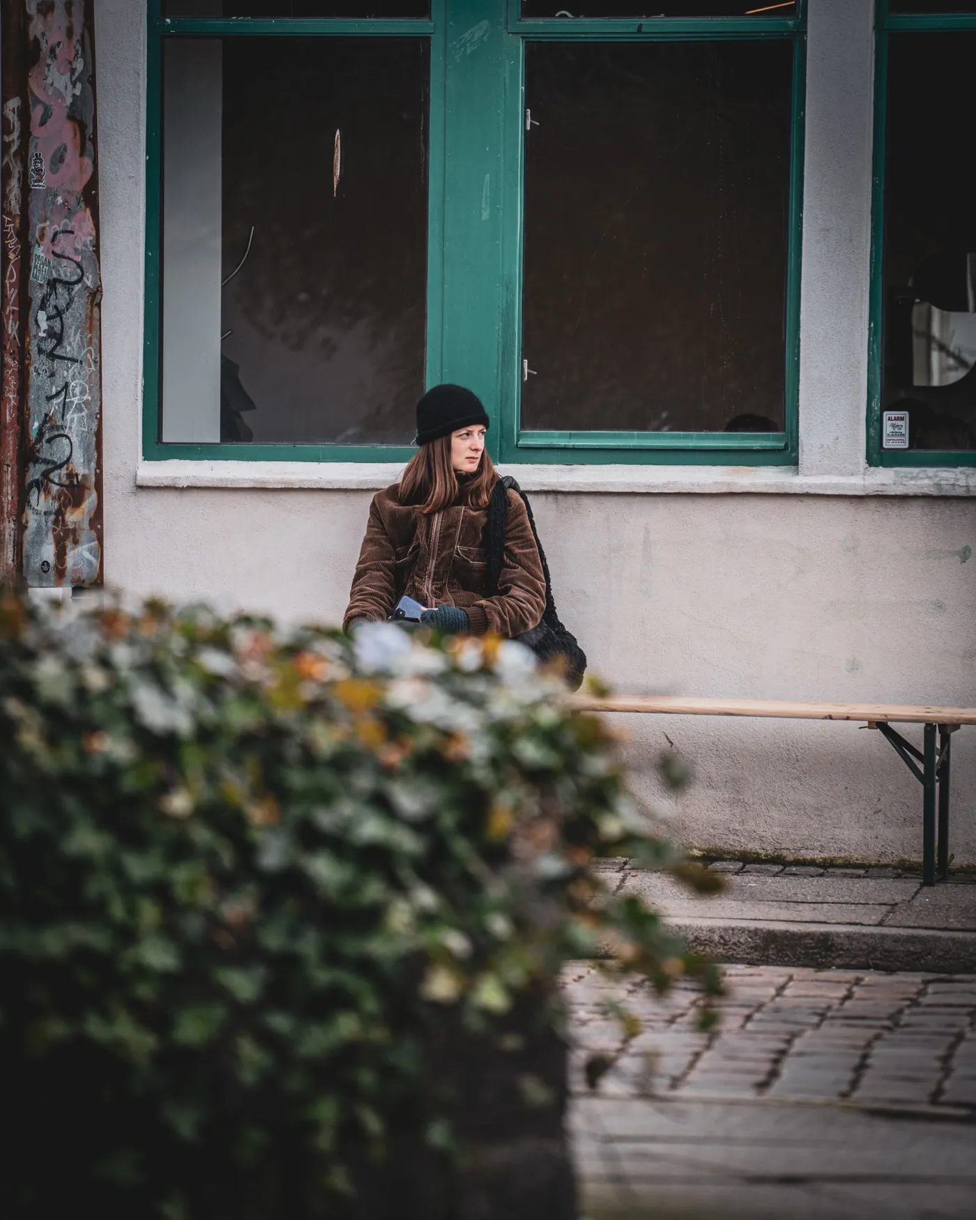 Fotografi af Mads Dyg: Person sidder foran bygning