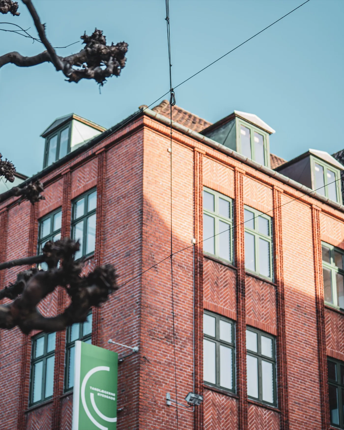 Fotografi af Mads Dyg: Rød murstensbygning mod blå himmel